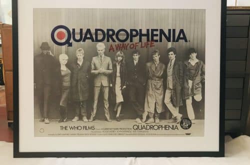 Framed Quadrophenia poster featuring a black-and-white photo of The Who band members with the title 'Quadrophenia' above them on a light background with a white mat and dark frame.